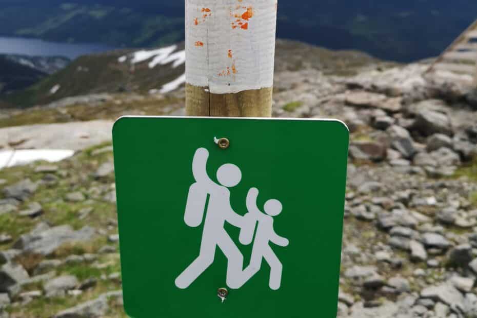Grön skylt för vandringsled med utsikt över fjället i bakgrunden